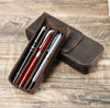 Slim leather pen case displayed beside writing tools