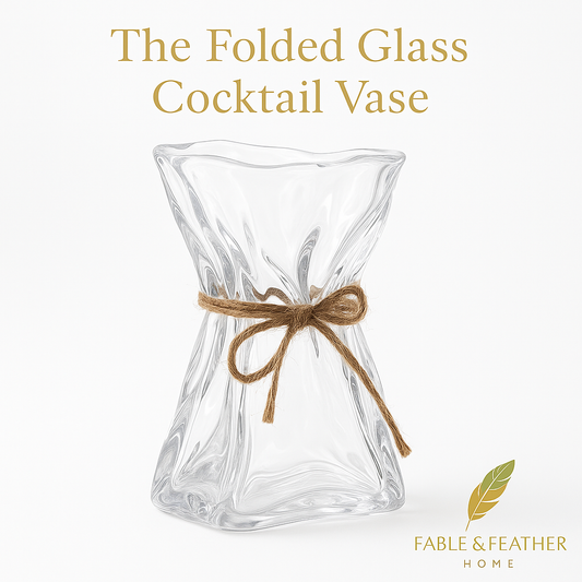 The Folded Glass Cocktail Vase by Fable & Feather Home, clear sculptural cocktail glass with twine accent on a white background.