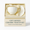 Satin-lined presentation box containing gold-rimmed ceramic teacup set