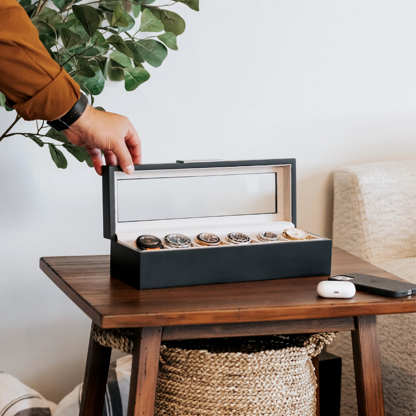 Matte black watch organizer on wooden table